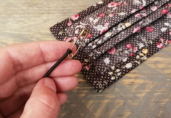 Trä tråd genom gummiband